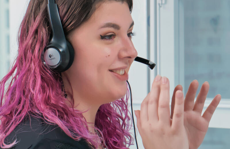 Benefits of live call answering: closeup of a virtual receptionist talking on a headset
