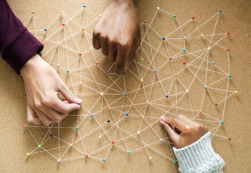 Omnichannel customer experience: hands connect pins on a board with string