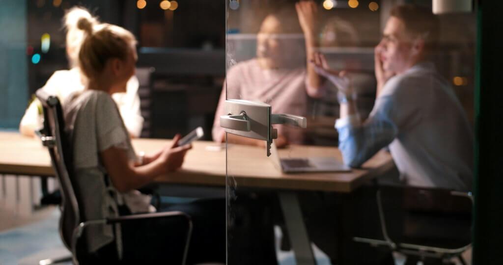 A blurry group of people sit at a table behind an open glass door. Read Ruby's list of 9 things to do for yourself before returning to the office.