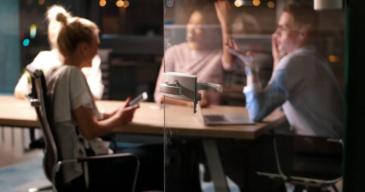 Business meeting occurring behind ajar glass door