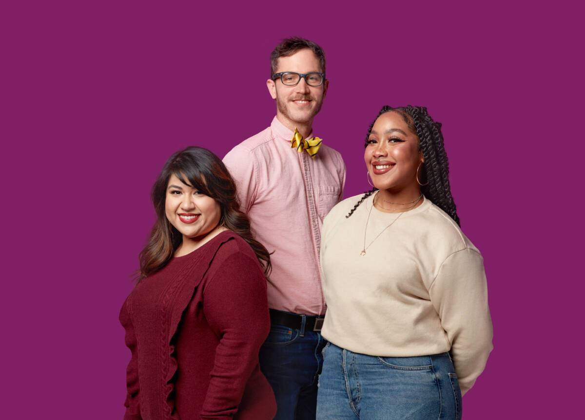 Three Ruby team members stand together and smile at the camera
