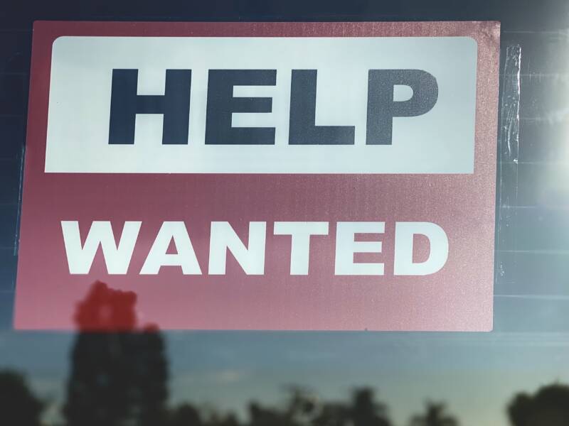 Help wanted sign hung in reflective window