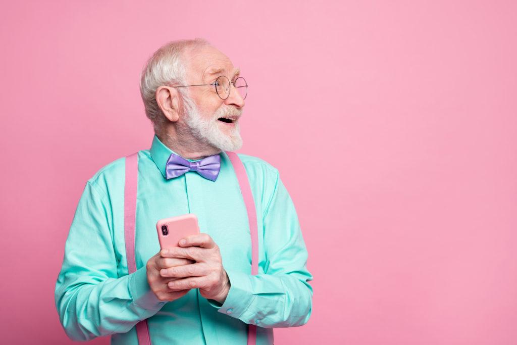 A white-bearded man looks beyond the frame with a happily surprised expression on his face.