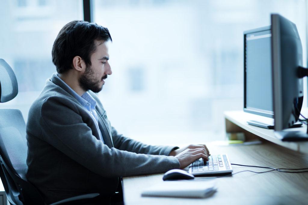 Professional sitting at desk on computer, working on a law firm website