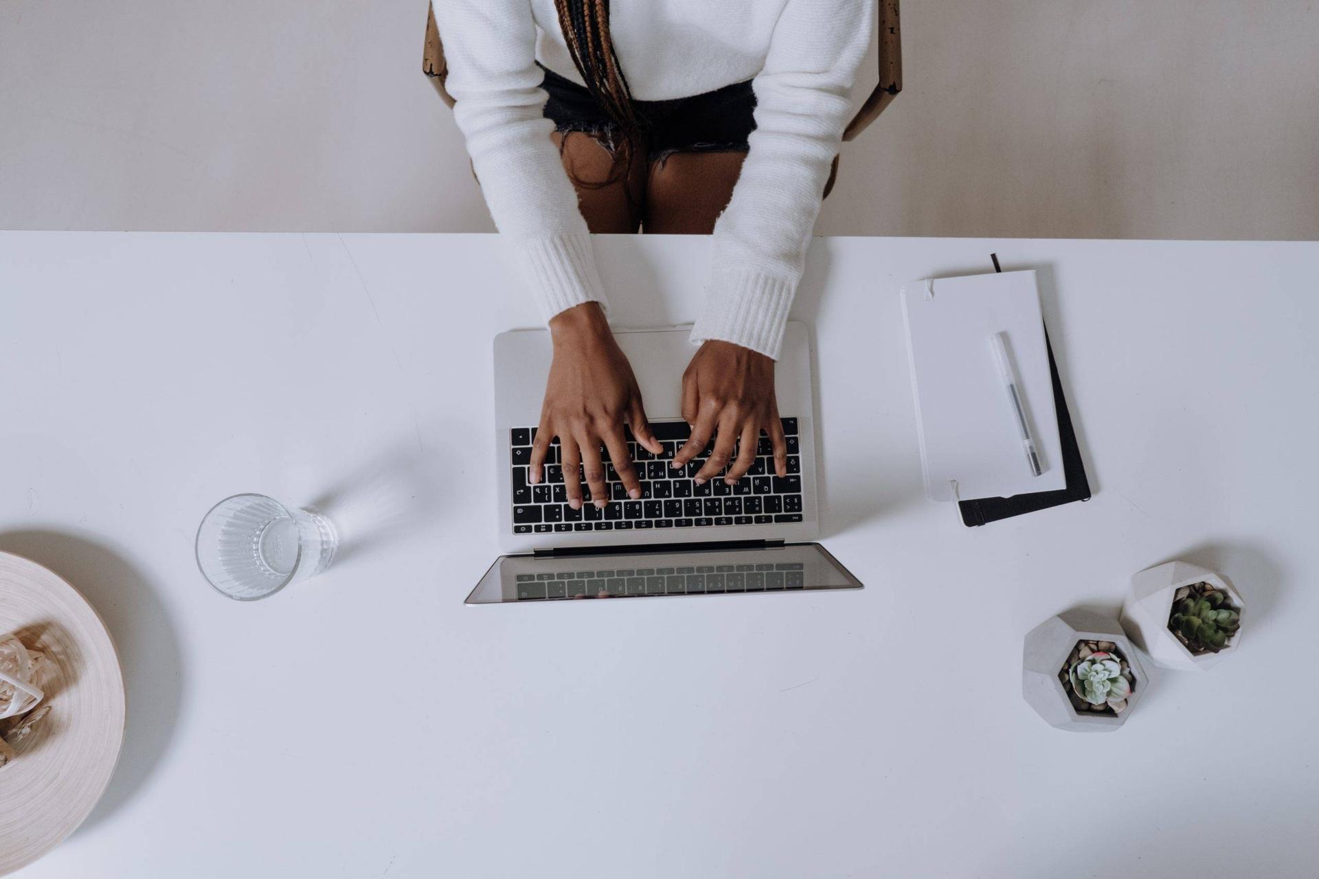 Overhead view of a woman typing at desk