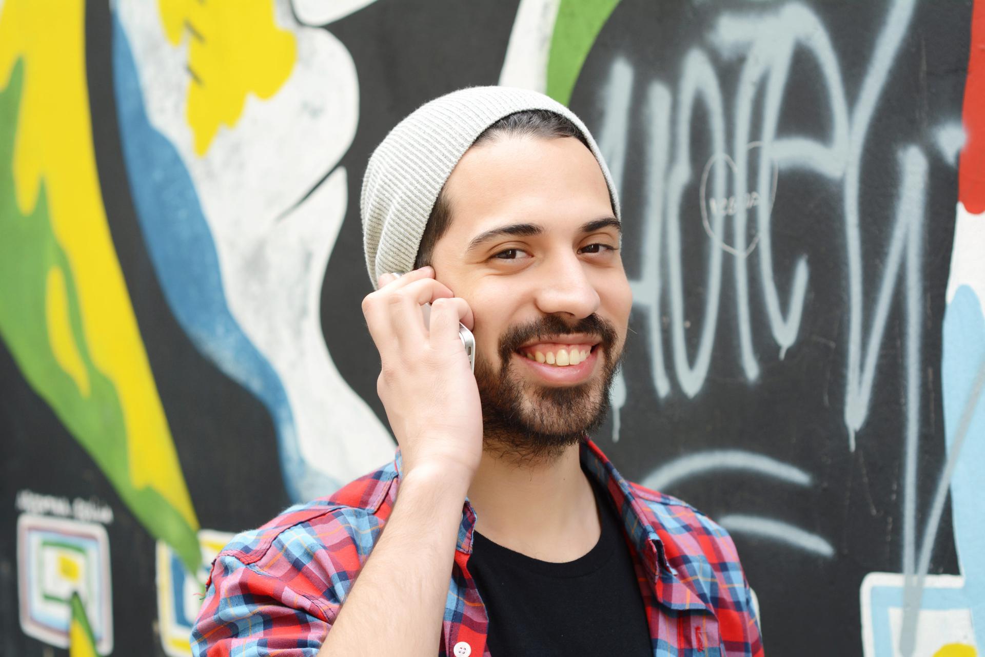 Carlos smiling and holding a phone