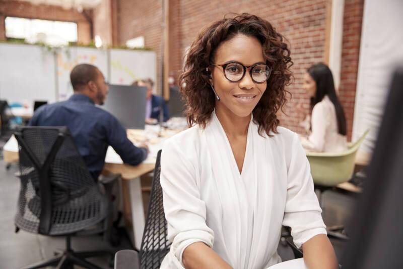 Female Customer Services Agent Working At Desk In Call Center