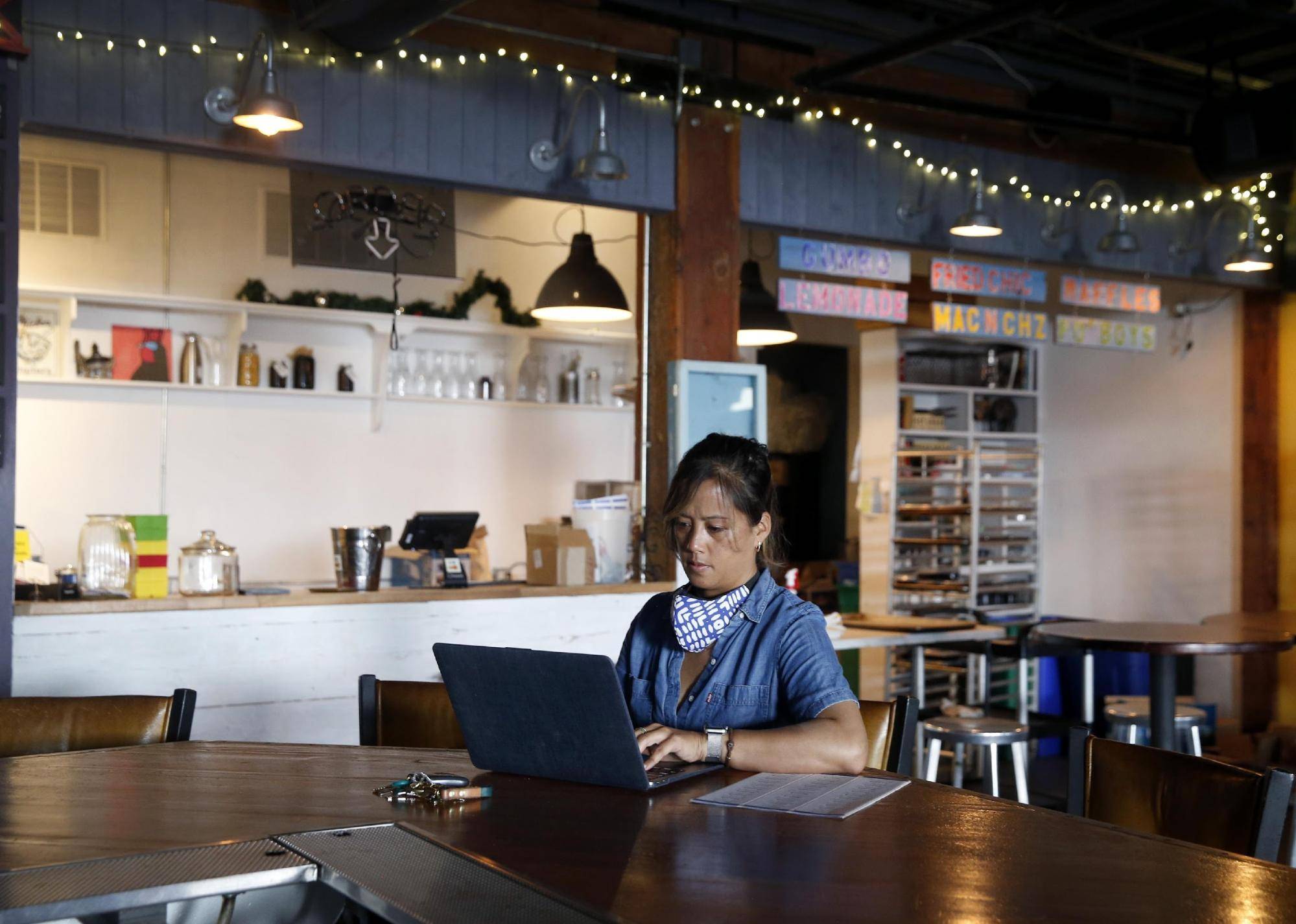 3 most common SBA loans: person working at a laptop at a table in an empty cafe