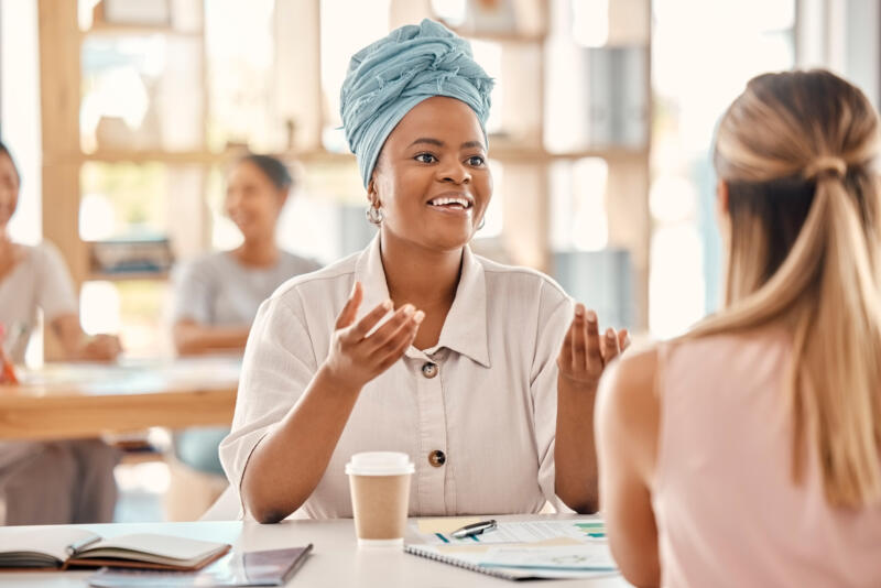 What does it mean to sound professional: dark-skinned woman speaks confidently to colleague