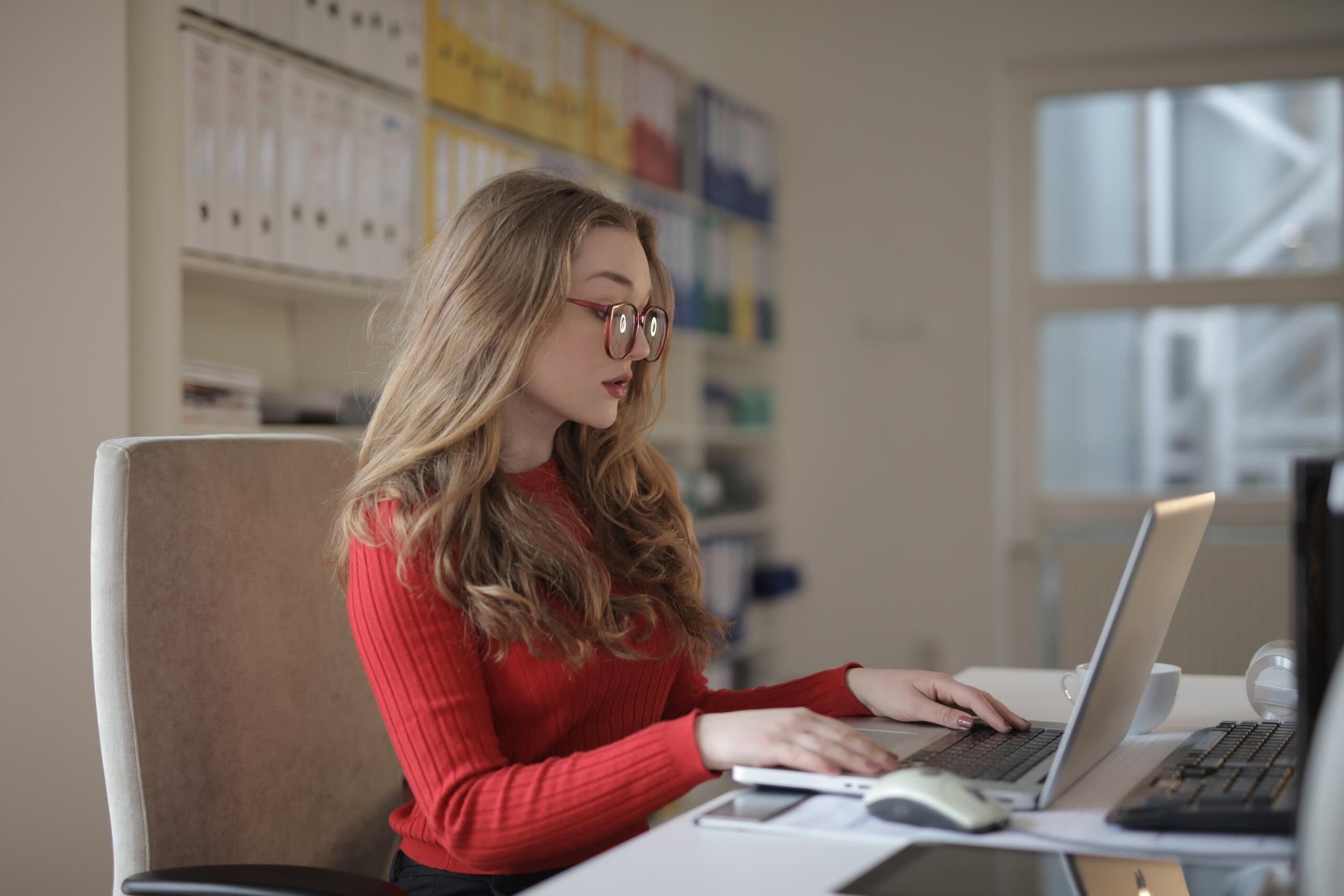 6 ways virtual receptionists make tax season easier: woman at desk works at computer