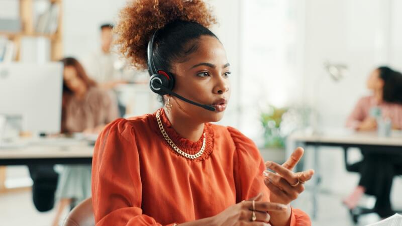 woman in orange top with headset