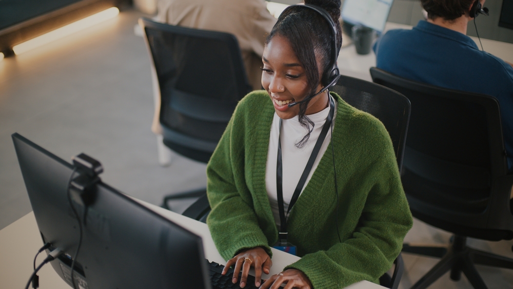virtual receptionist wearing green sweater at work