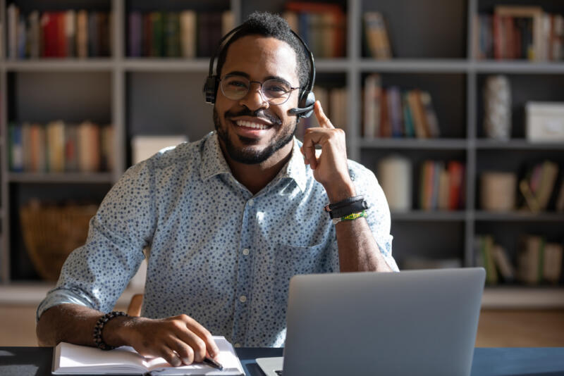 smiling virtual receptionist wearing a headset in a button down shirt
