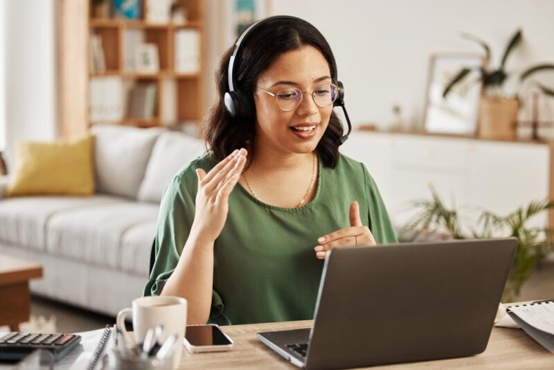 female small business virtual receptionist with headset wearing green