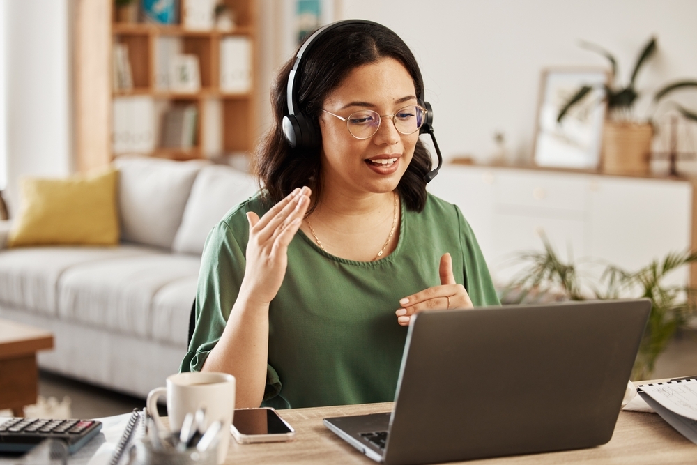 female small business virtual receptionist with headset wearing green