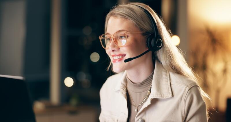 wealth management virtual receptionist with glasses smiling at computer screen