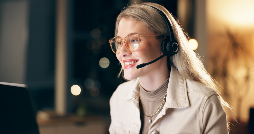 wealth management virtual receptionist with glasses smiling at computer screen