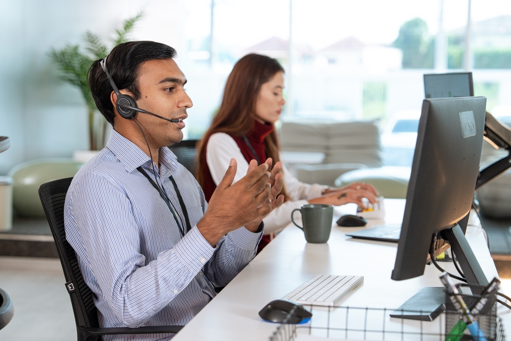 hvac virtual receptionist team working at a shared desk wearing headsets